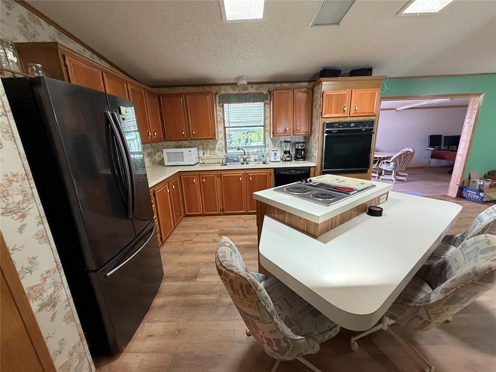 An office space features a wooden desk, a round table with chairs, and light-colored flooring — 2532 AMYRIS COURT UNIT 601, ZELLWOOD, FL