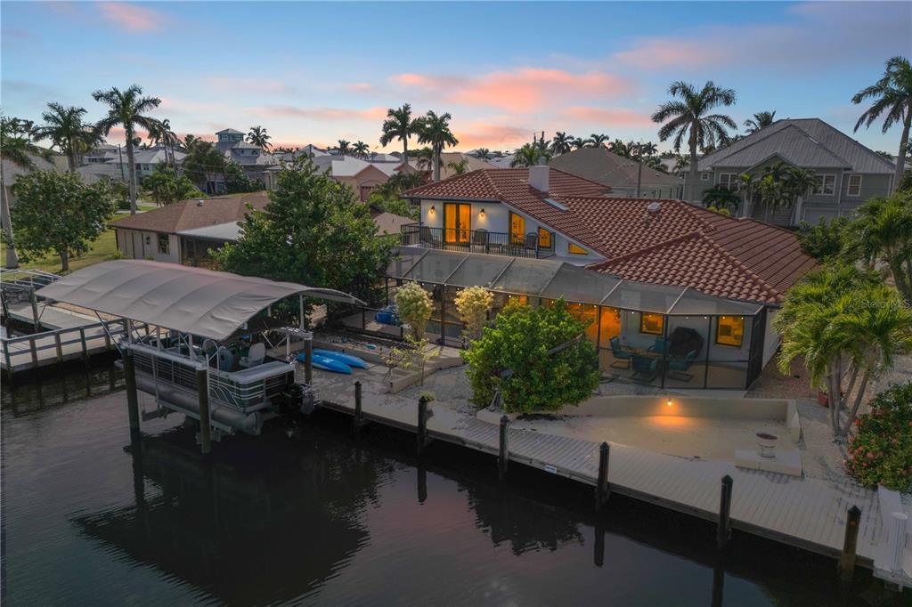 An aerial view of a waterfront house with a boat lift, dock, and screened patio — 2420 CHERIMOYA LANE, ST JAMES CITY, FL