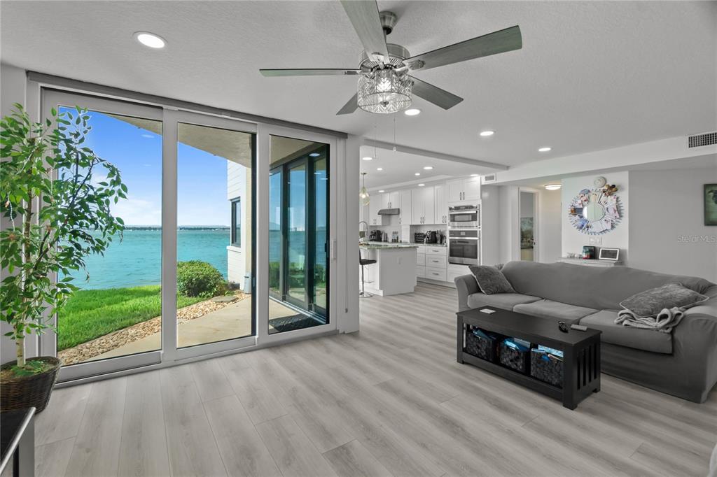 A living room with a gray sofa, black coffee table, and white kitchen cabinets — 5505 LA PUERTA DEL SOL BOULEVARD S UNIT 126, ST PETERSBURG, FL