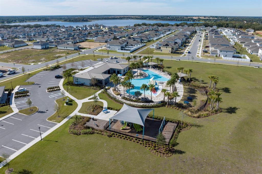 An aerial view shows a community clubhouse with a swimming pool and a playground — 7040 ROLLING LEAF ROAD, GROVELAND, FL