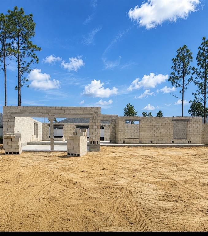 A construction site shows the concrete block walls of a house under a blue sky — 8441 N INCA WAY, DUNNELLON, FL