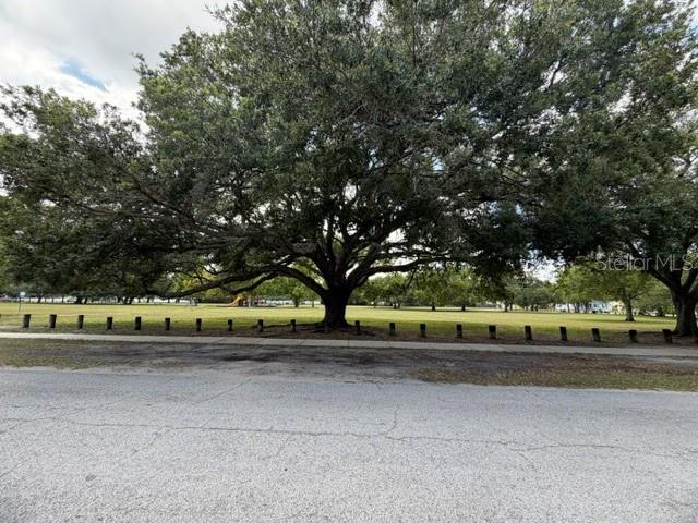 A vacant residential lot is enclosed by a black silt fence with a real estate sign — 1006 W ADALEE STREET, TAMPA, FL
