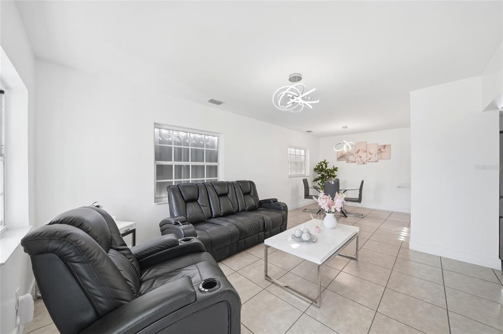 A living room with black leather furniture, a white coffee table, and tile flooring — 465 E 38TH STREET, HIALEAH, FL