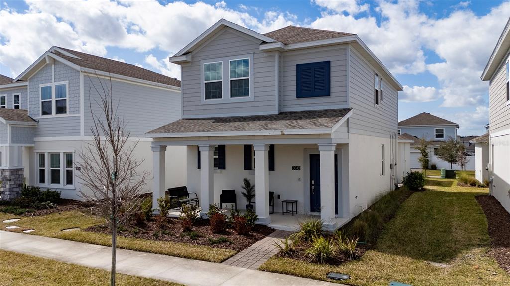 A two-story house with light gray siding, a covered front porch, and a blue door — 3040 PARK VALE ROAD, ST CLOUD, FL