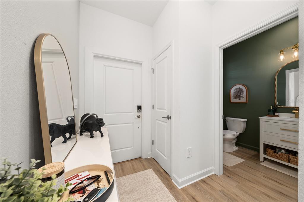 An entryway features a white door, a floor mirror, and a doorway to a bathroom — 3040 PARK VALE ROAD, ST CLOUD, FL