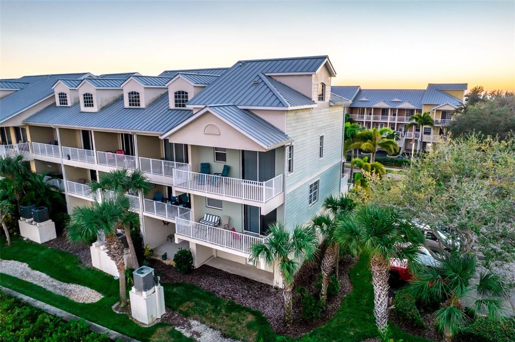 An exterior view of a multi-story residential building with balconies and a metal roof — 465 BAHIA BEACH BOULEVARD, RUSKIN, FL