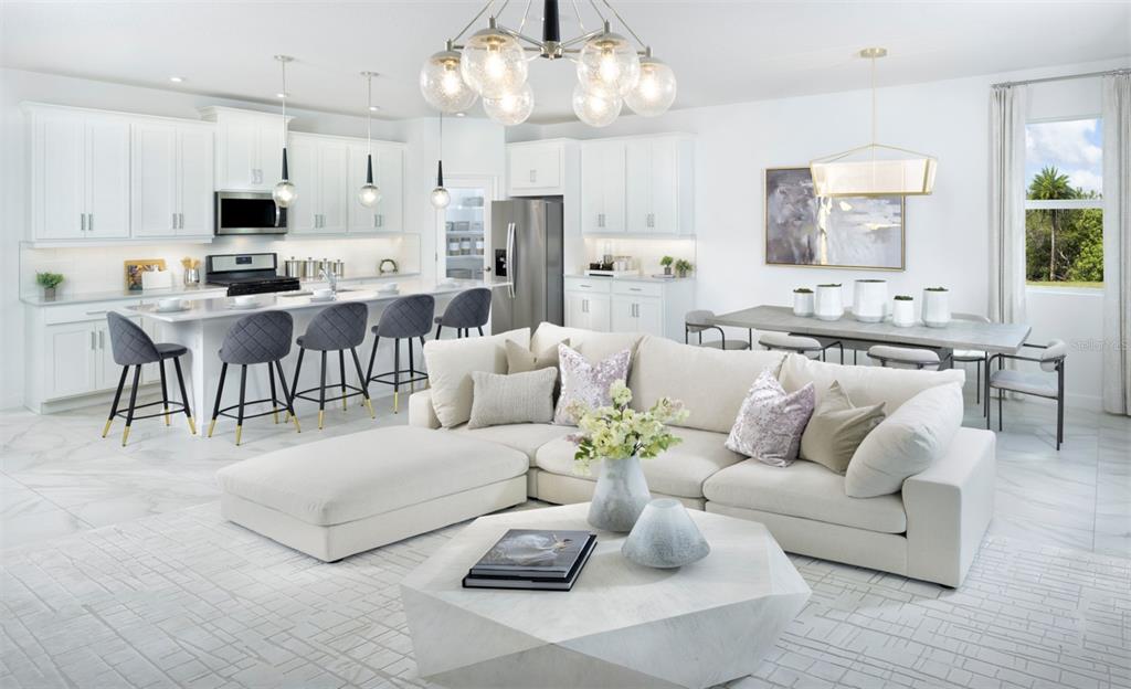 A bright open-concept kitchen and living area features white cabinetry, a large sectional, and tile — 18501 VISTA PARK, VENICE, FL