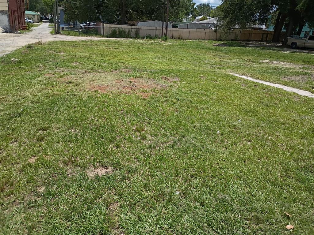 A grassy, vacant residential lot is enclosed by a wooden fence — 15 W SESSOMS AVENUE, LAKE WALES, FL