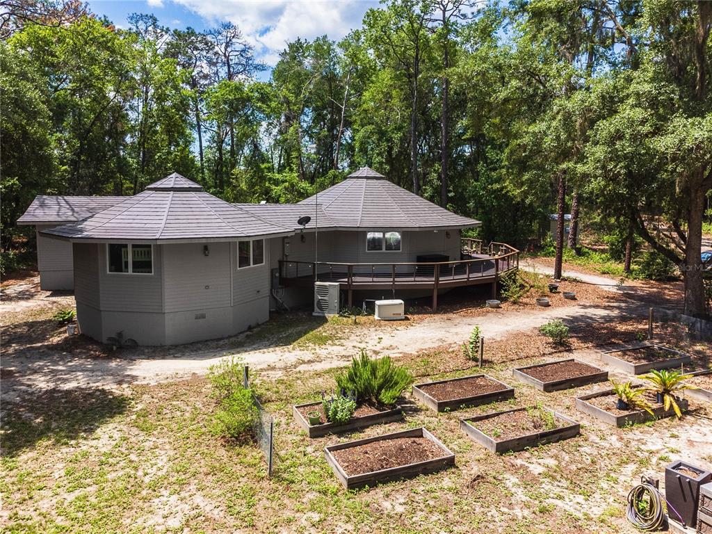 An aerial view shows a house with three connected circular roofs surrounded by trees — 13797 NE 199TH STREET, WALDO, FL