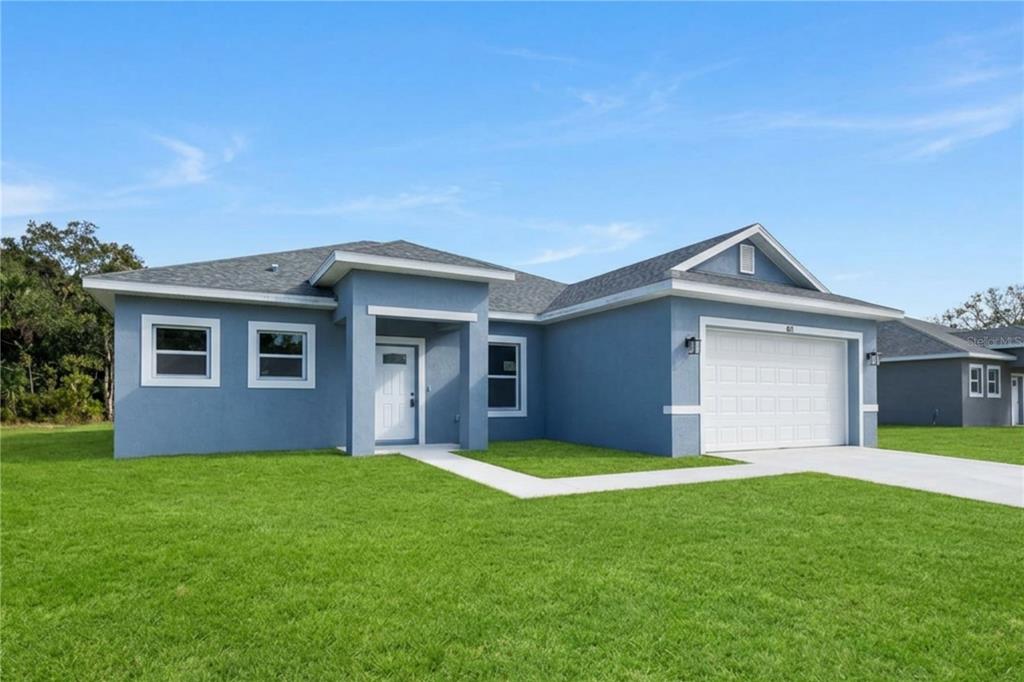 An open-concept living area features light-colored tile flooring, a kitchen island, and sliding glass doors — 415 TONKLIN ROAD SW, PALM BAY, FL