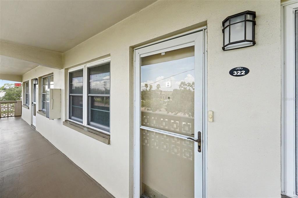 An exterior view of a building hallway showing a door labeled 322 and windows — 951 79TH AVENUE N APT 322, ST PETERSBURG, FL