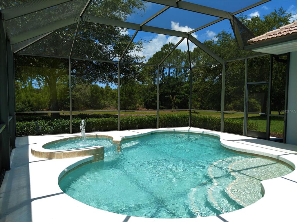 A screened-in swimming pool and spa with a fountain feature and a patio area — 919 SCHERER WAY, OSPREY, FL