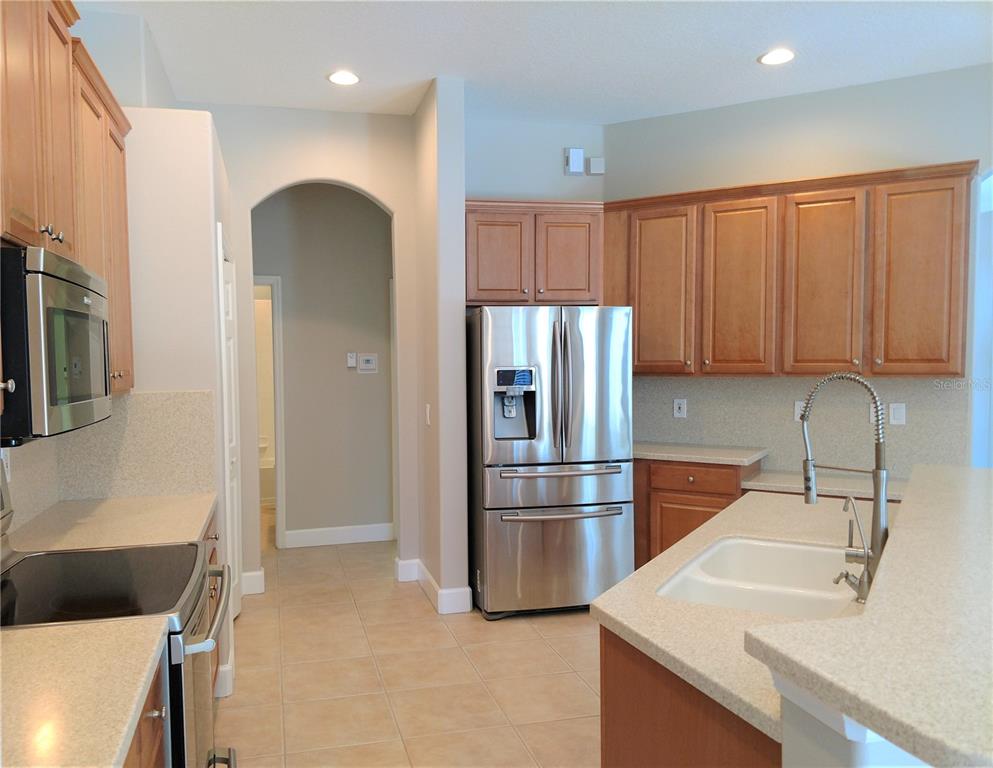 A kitchen with wood cabinets, stainless steel appliances, and light-colored countertops — 919 SCHERER WAY, OSPREY, FL