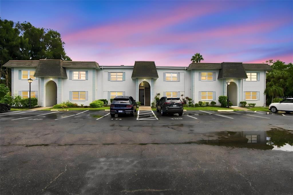 A two-story apartment building exterior features a central arched entryway and a paved parking lot — 217 S MCMULLEN BOOTH ROAD UNIT 179, CLEARWATER, FL