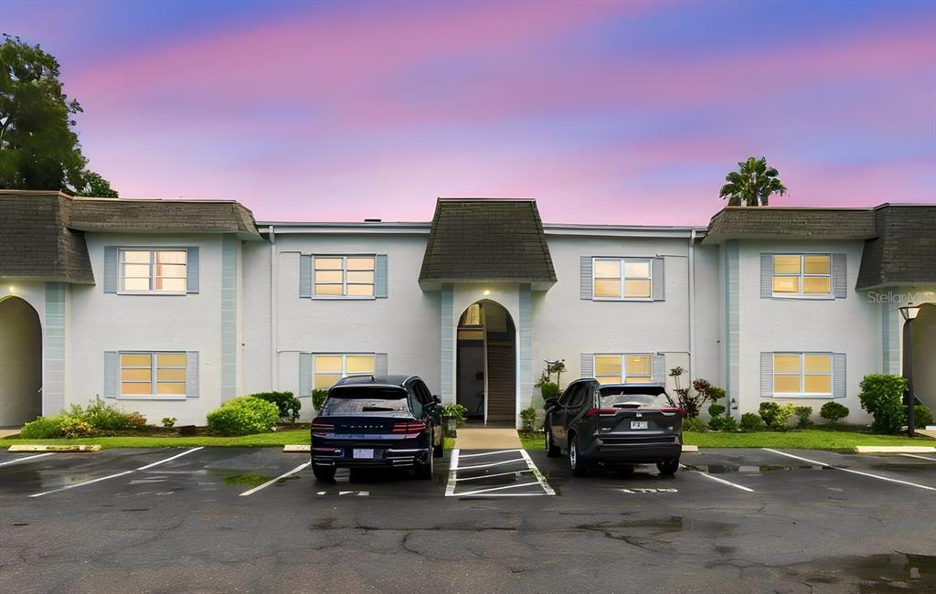 A two-story apartment building exterior with a central entryway and parking spaces in front — 217 S MCMULLEN BOOTH ROAD UNIT 179, CLEARWATER, FL