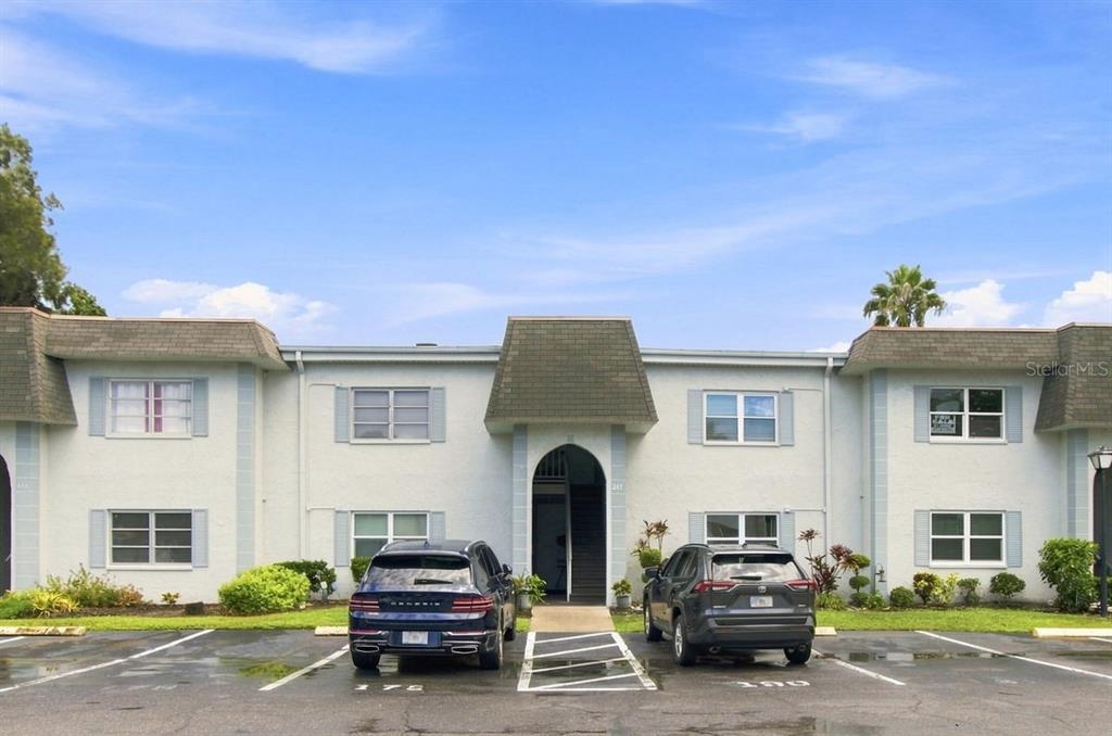 A white screen door is mounted on a textured exterior wall next to a wooden mailbox — 217 S MCMULLEN BOOTH ROAD UNIT 179, CLEARWATER, FL