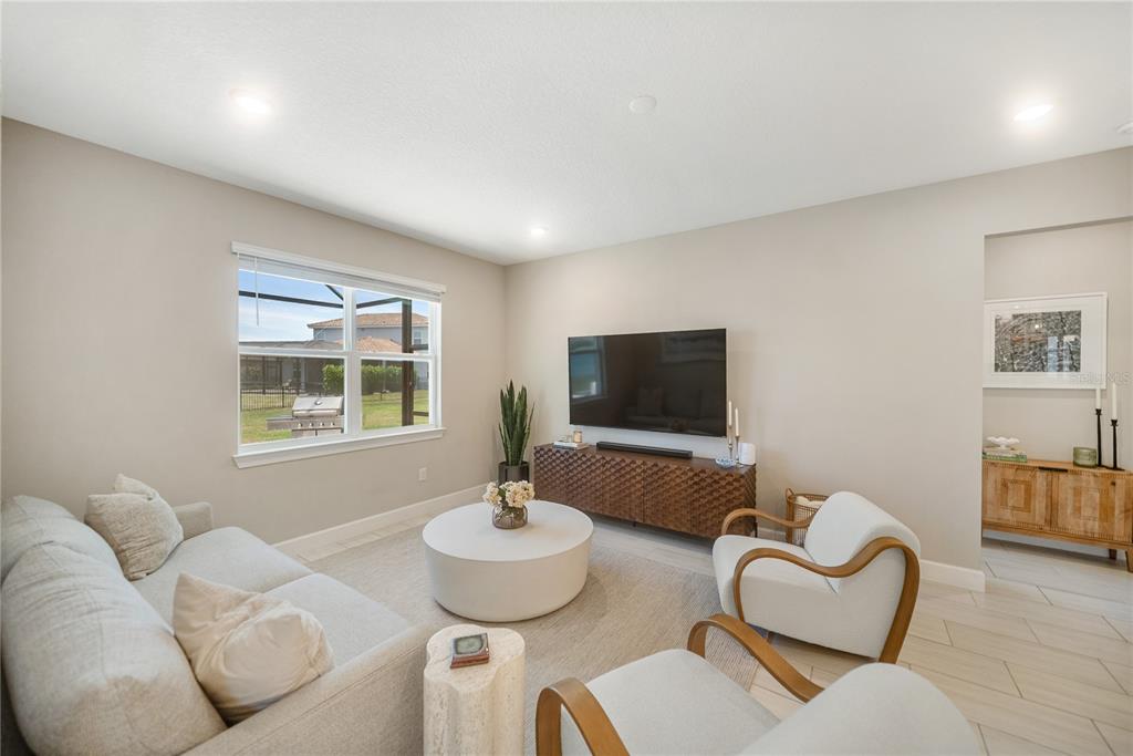 A living room features a light-colored sofa, two armchairs, a round coffee table, and television — 3312 BIG SKY WAY, BRADENTON, FL