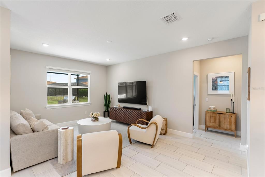 A living room features a sofa, two armchairs, a coffee table, and a wall-mounted television — 3312 BIG SKY WAY, BRADENTON, FL