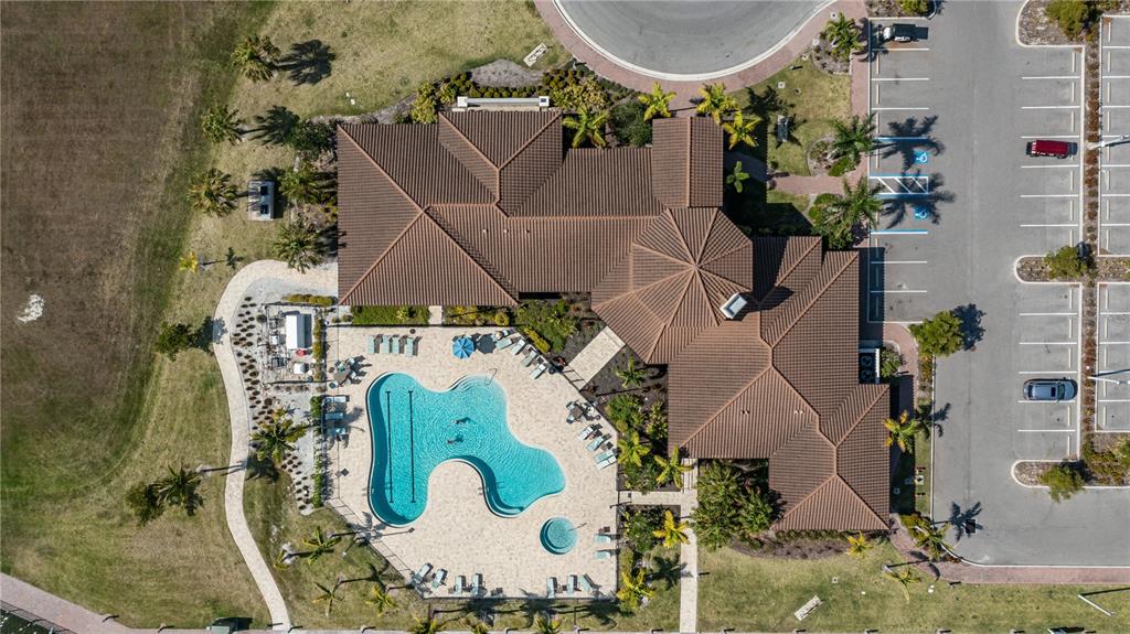 An aerial view shows a building with a tiled roof, a swimming pool, and parking — 2121 6TH STREET E, PALMETTO, FL