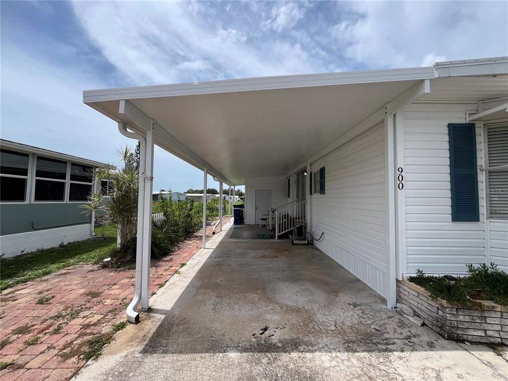 A white manufactured home features a covered carport and a concrete driveway — 900 JOLANDA CIRCLE, VENICE, FL
