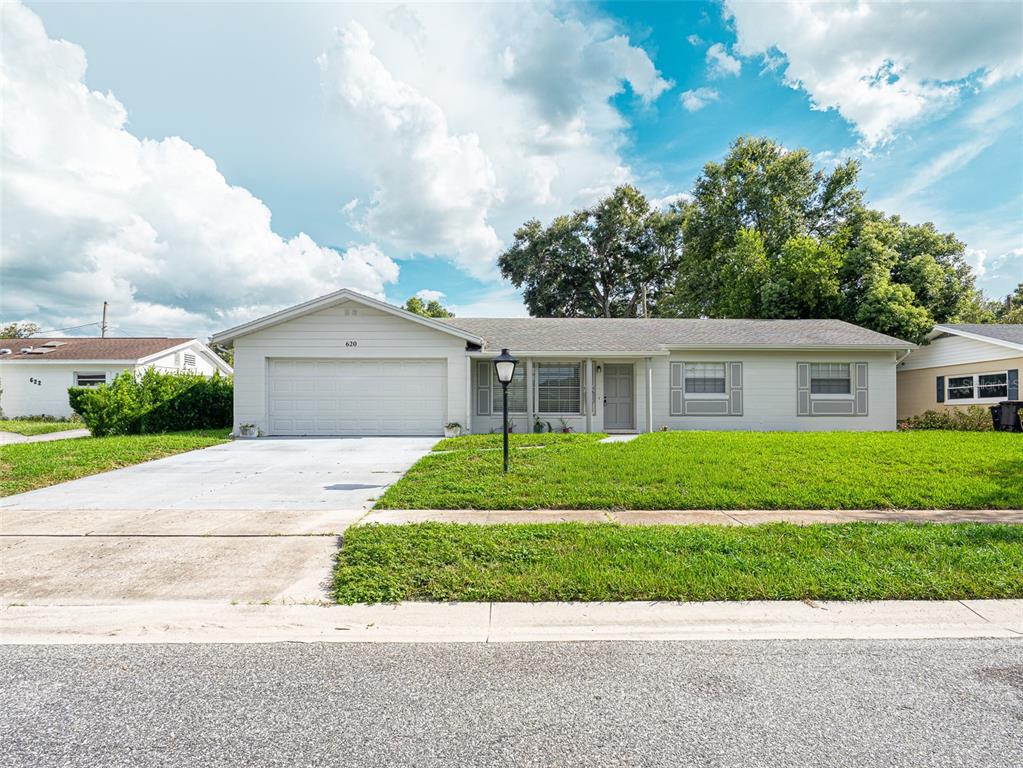 A single-story house with a light-colored exterior, a two-car garage, and a front lawn — 620 BURKE STREET, ALTAMONTE SPRINGS, FL