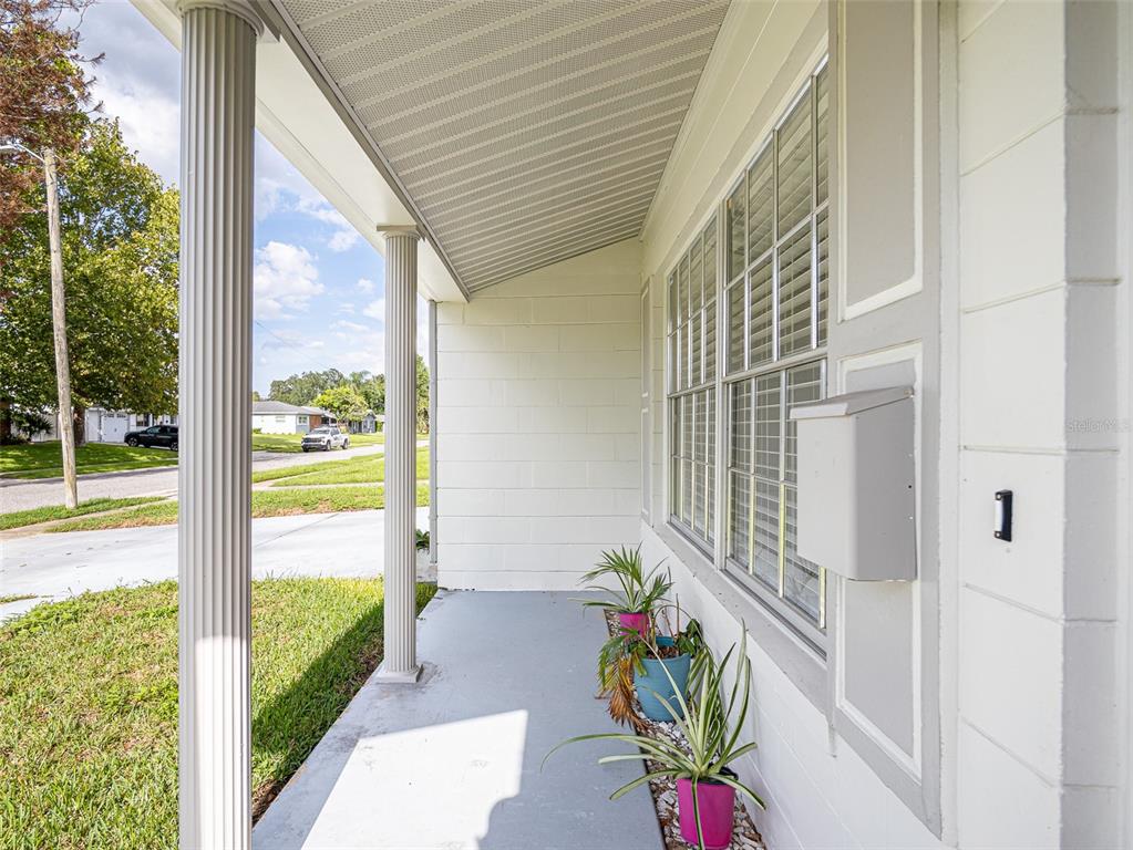 A covered front porch with white columns, a gray floor, and potted plants — 620 BURKE STREET, ALTAMONTE SPRINGS, FL