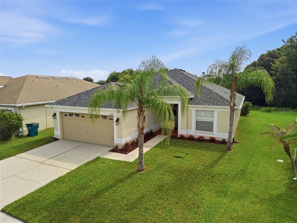 An exterior view of a home entrance with a brown door and a corner window — 31522 TRIBOROUGH DRIVE, WESLEY CHAPEL, FL
