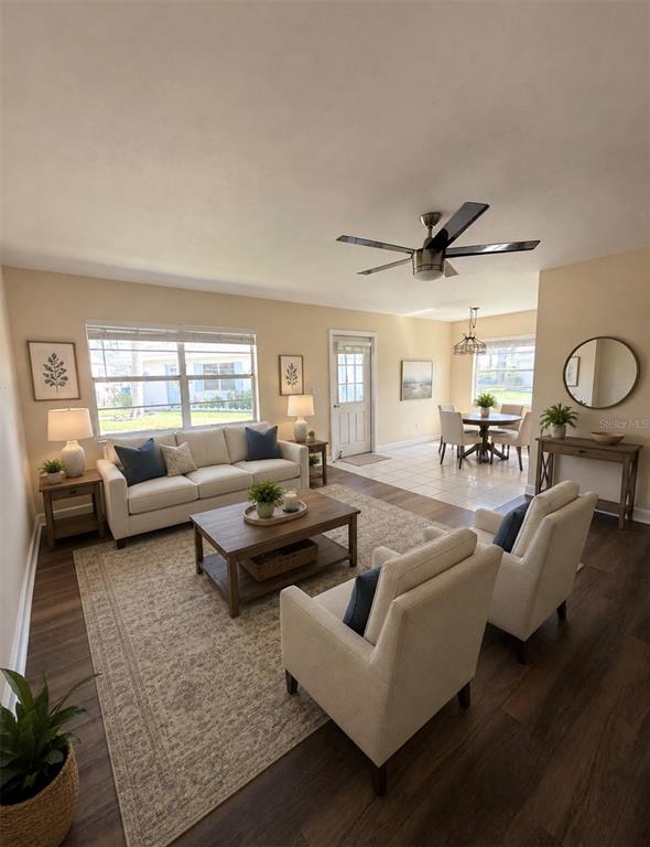 A living room with a sofa, two armchairs, a coffee table, and an adjacent dining area — 402 DORCHESTER PLACE UNIT 44, SUN CITY CENTER, FL