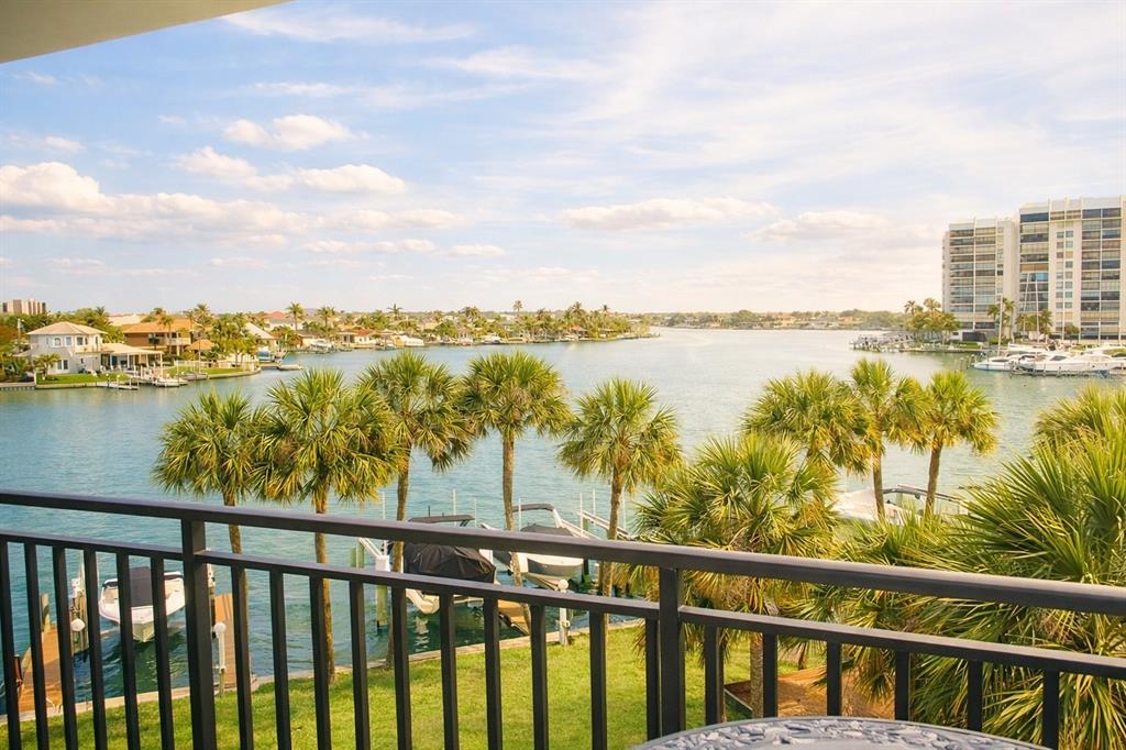 An aerial view shows a waterfront condominium complex with a pool and boat slips — 9825 HARRELL AVENUE UNIT 404, TREASURE ISLAND, FL