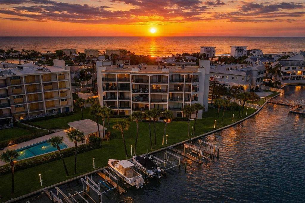 A boat is lifted on a mechanical dock system over clear blue water — 9825 HARRELL AVENUE UNIT 404, TREASURE ISLAND, FL