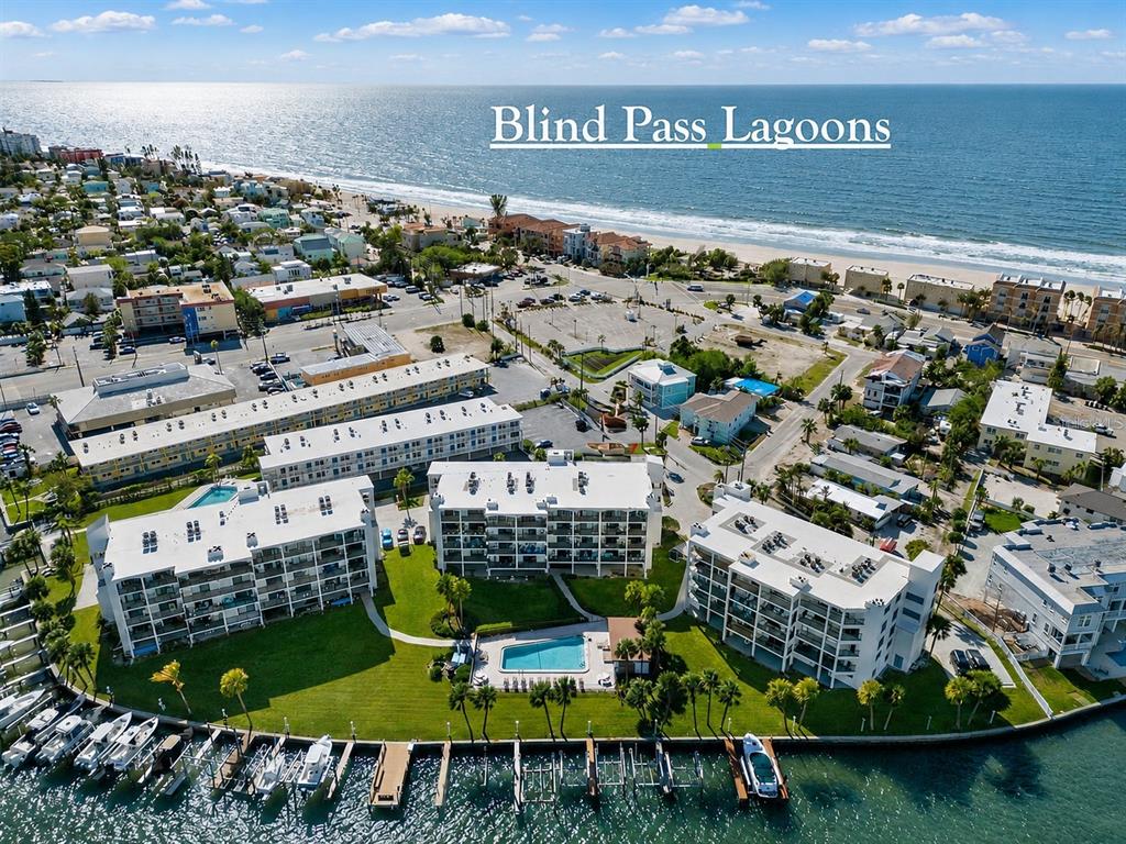 An aerial view of a waterfront condominium complex with a pool and boat slips — 9825 HARRELL AVENUE UNIT 404, TREASURE ISLAND, FL