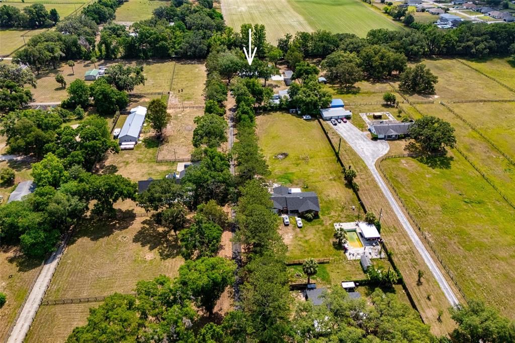 An aerial view shows multiple rural properties with houses, outbuildings, and trees along a road — 6875 NE 25TH AVENUE, OCALA, FL