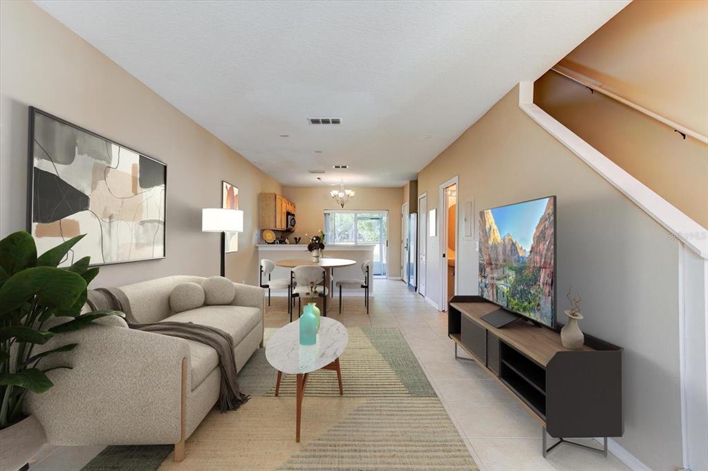An open-concept living area features tile flooring, a kitchen breakfast bar, and a carpeted staircase — 509 WILTON CIRCLE, SANFORD, FL