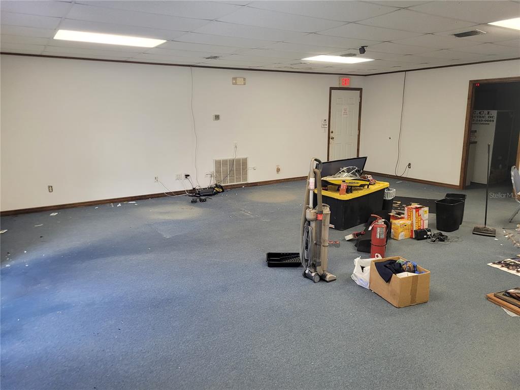 An empty commercial office space with blue carpeting, white walls, and a drop ceiling — 8875 E HIGHWAY 25, BELLEVIEW, FL