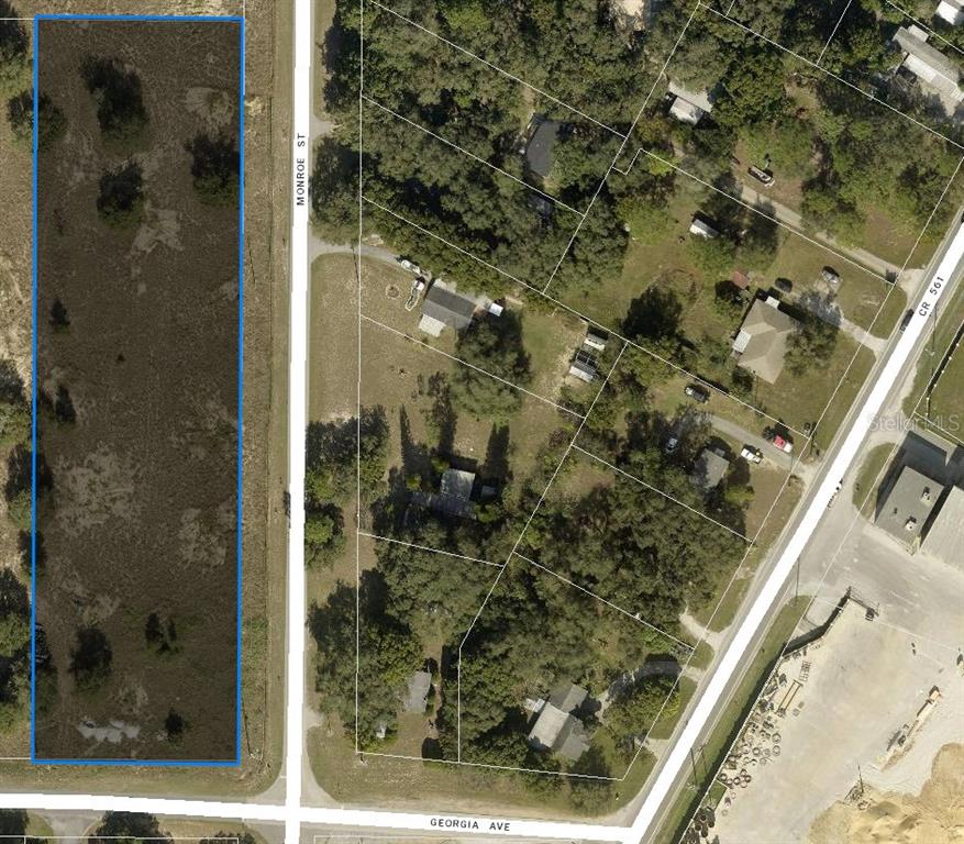 This aerial map shows a vacant rectangular lot outlined in blue next to a residential area — TBD MONROE STREET, ASTATULA, FL