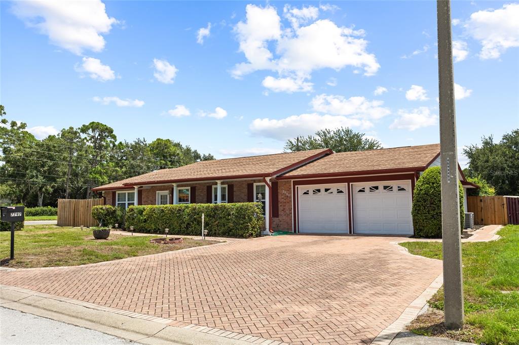 A single-story brick house with a two-car garage and a paved driveway — 7797 132ND WAY, SEMINOLE, FL