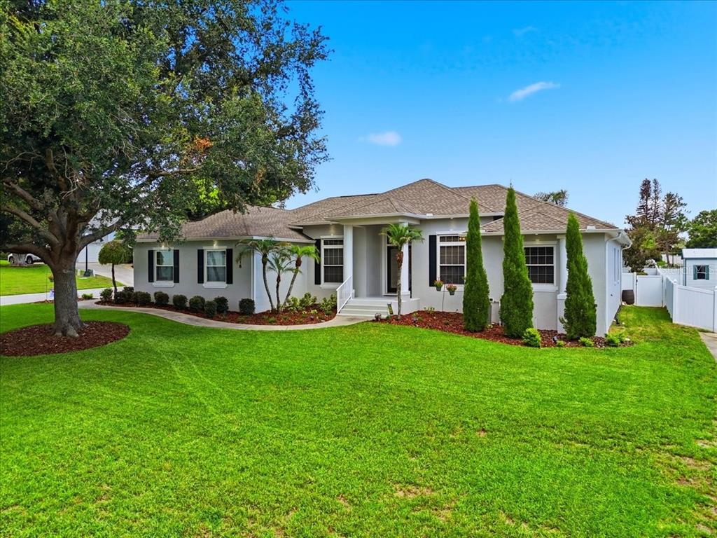 A single-story house with a gray exterior, a large front lawn, and a mature tree — 5618 SUMMERLAND HILLS DRIVE, LAKELAND, FL