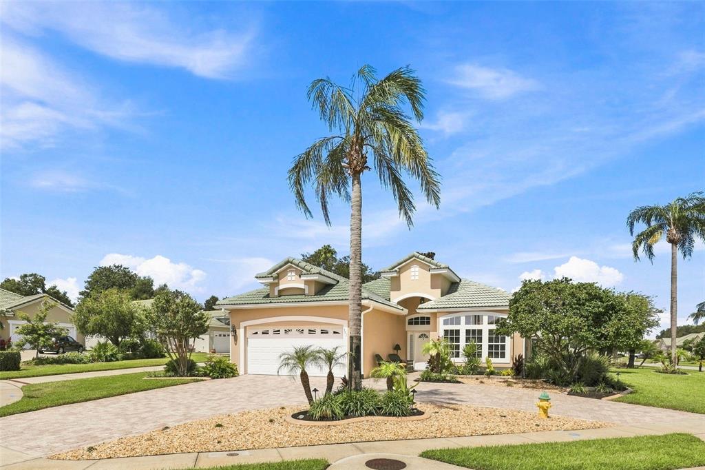 A single-story house with a beige stucco exterior, green tile roof, and a palm tree — 367 FOXHILL DRIVE, DEBARY, FL