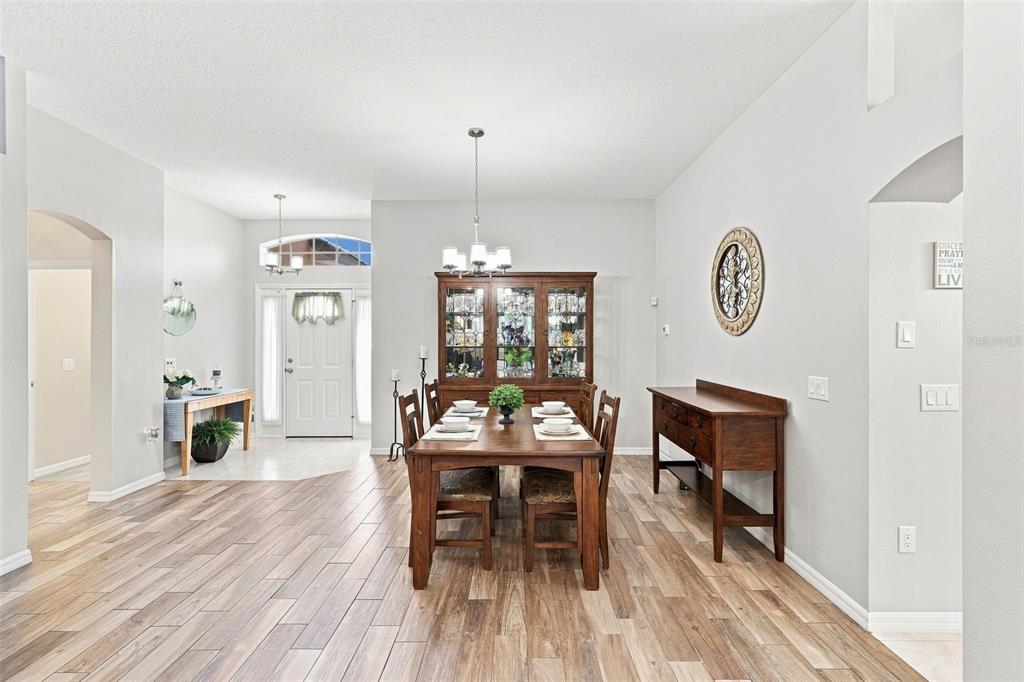 A dining room features a wooden table, a china cabinet, and wood-look tile flooring — 367 FOXHILL DRIVE, DEBARY, FL
