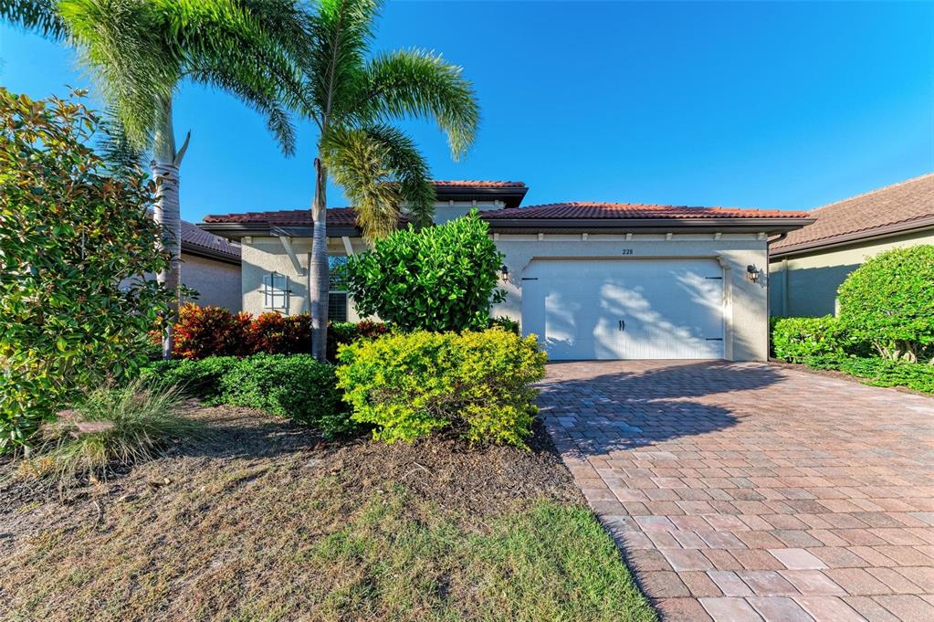 A single-story house with a paved driveway, a two-car garage, and palm trees in front — 228 MARAVIYA BOULEVARD, NOKOMIS, FL