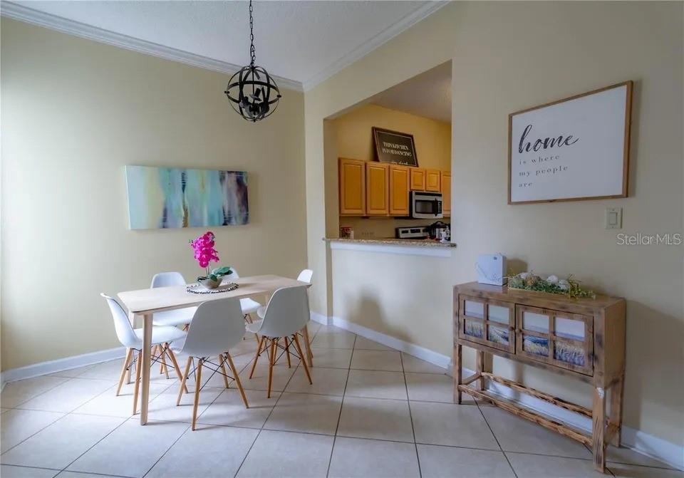 A dining area with a table, chairs, and a wooden console table near a kitchen — 2545 CLARINET DRIVE, ORLANDO, FL