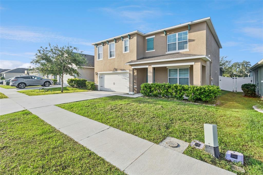 A two-story suburban house with a tan stucco exterior, a two-car garage, and a lawn — 29505 CASPIAN STREET, LEESBURG, FL