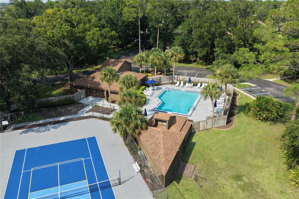 An aerial view shows a swimming pool, a tennis court, and a small clubhouse building — 37 HEMBURY LANE, PALM COAST, FL