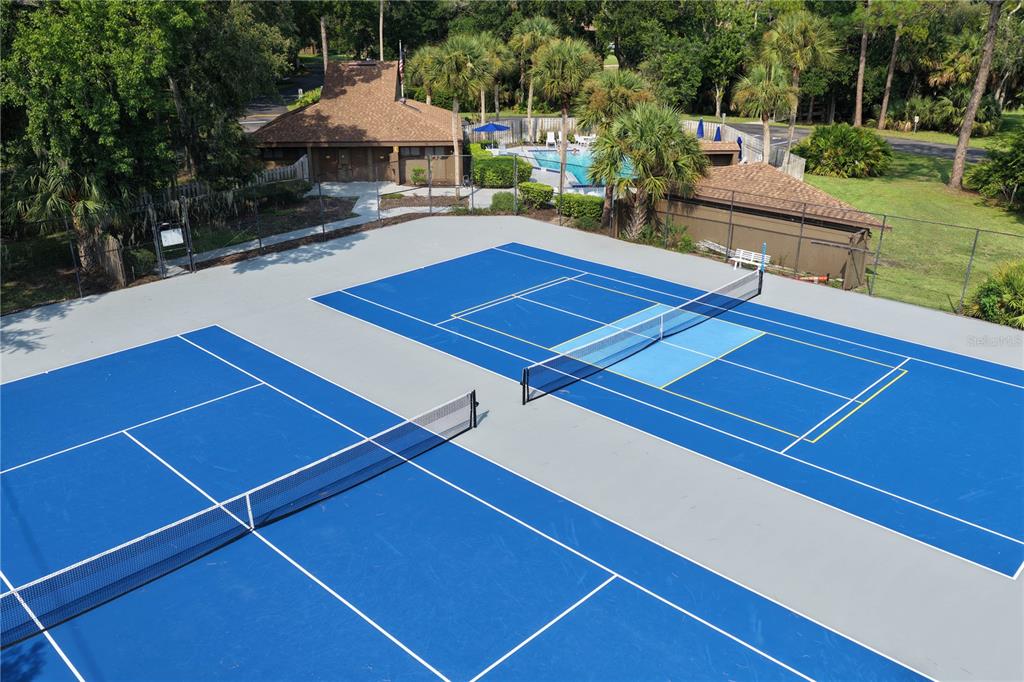 An aerial view of two blue tennis courts with nets and a nearby swimming pool — 37 HEMBURY LANE, PALM COAST, FL