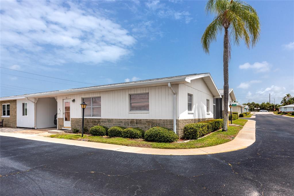 A single-story building with white siding and a palm tree in the front yard — 12400 PARK BOULEVARD UNIT 417, SEMINOLE, FL