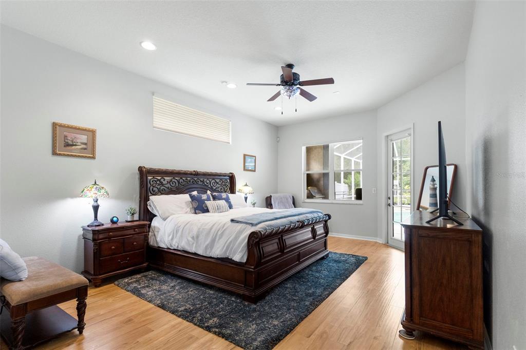 A kitchen features white cabinetry, granite countertops, a blue glass tile backsplash, and an island — 8380 GOLDEN PRAIRIE DRIVE, TAMPA, FL