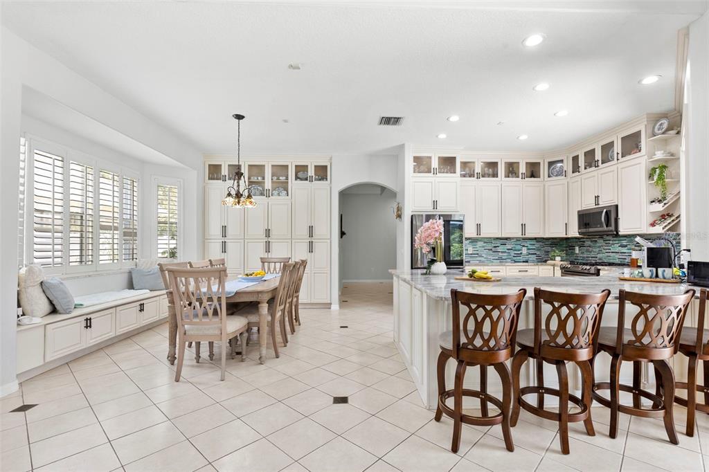 A bathroom features a central soaking tub, marble tile, dual vanities, and glass block windows — 8380 GOLDEN PRAIRIE DRIVE, TAMPA, FL
