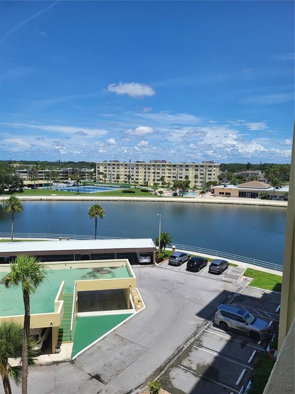 An elevated view shows a parking lot, a lake, and a large apartment complex beyond — 4775 COVE CIRCLE UNIT 606, ST PETERSBURG, FL