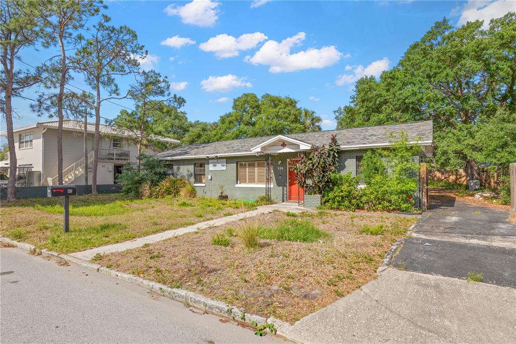 An aerial view shows a small house with a gray roof surrounded by mature trees — 110 N LINCOLN AVENUE, TAMPA, FL