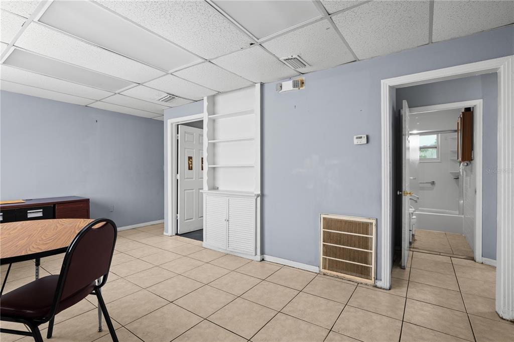 A home office features a wooden desk, a round table, and two framed wall pictures — 110 N LINCOLN AVENUE, TAMPA, FL